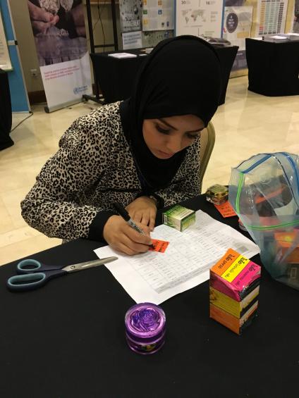 Nour Labidi preparing some of the cosmetics that contain mercury for display at the IPEN booth