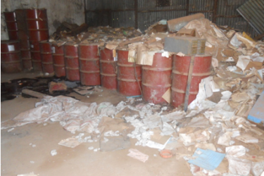 Drums of obsolete pesticides stored in the MOFACU warehouse with documents scattered on the floor