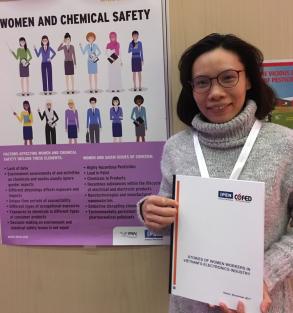 Hang Pham, Vice Director of CGFED, at the IPEN exhibit holding the "Stories of Women Workers in Vietnam's Electronics Industry" report