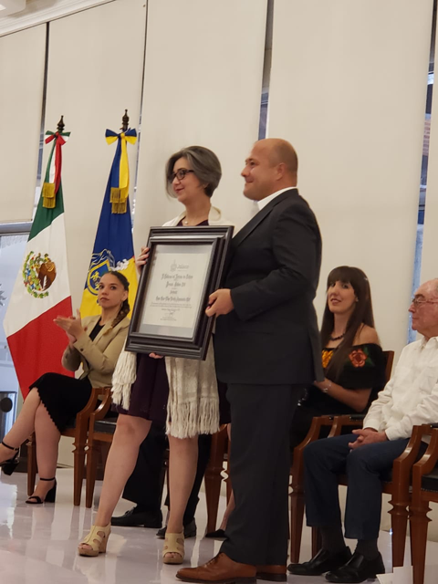 Sofia Chavez, Coordinadora General of Casa Cem, receives the award from Governor Enrique Alfaro Ramírez