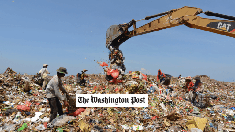 a crane in a large trash pile, Washington Post logo in foreground