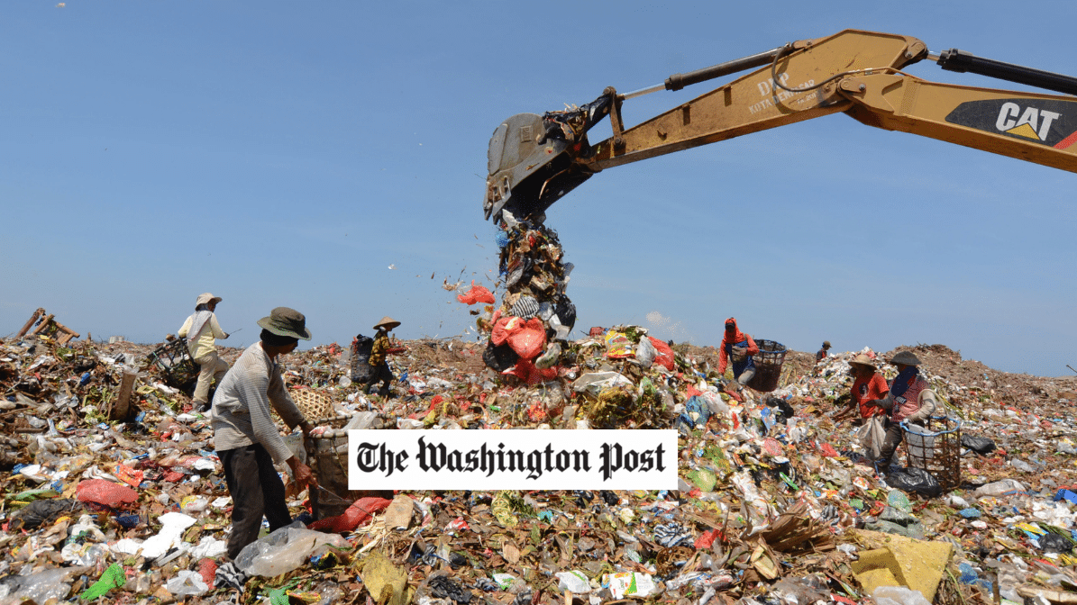 a crane in a large trash pile, Washington Post logo in foreground