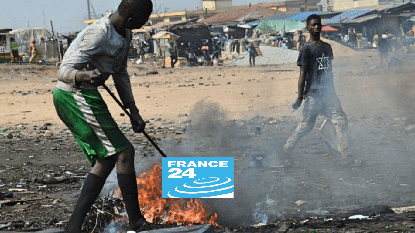 men burning a small pile of plastic trash, France24 logo in foreground