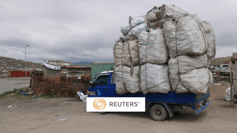 a truck piled high with trash, Reuters logo in foreground