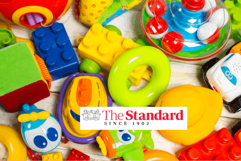 A variety of colorful childrens toys, including building blocks, cars, and animal figures, are spread out. In the center, there is a The Standard Since 1902 logo.