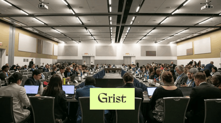 A large group of people sit at long tables arranged in a U-shape in a conference room, many using laptops. The word Grist appears in a green box at the bottom center of the image.