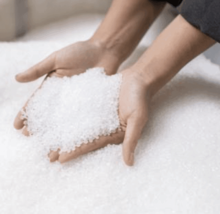 hands holding white plastic pellets