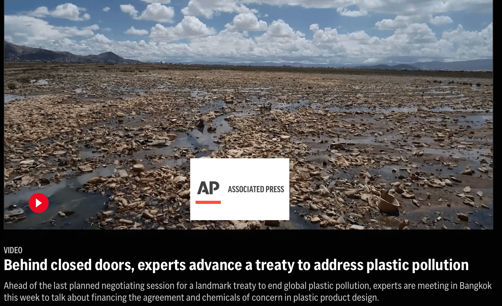 A vast, barren landscape is covered in plastic debris under a partly cloudy sky. In the background are distant mountains and a wide expanse of littered land. The Associated Press logo appears in the center of the image.