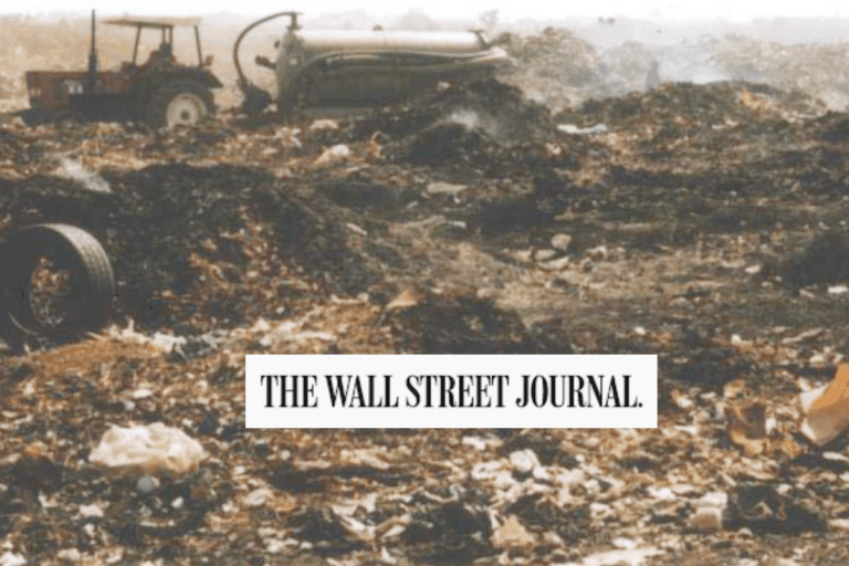 A tractor is parked among piles of garbage and debris at a landfill site. A large tank is visible in the background. The Wall Street Journal logo is overlaid at the bottom center of the image.