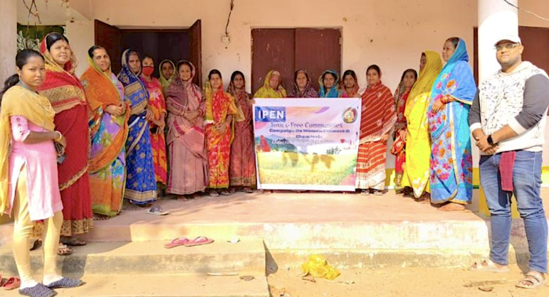 Women in colorful saris holding an IPEN banner