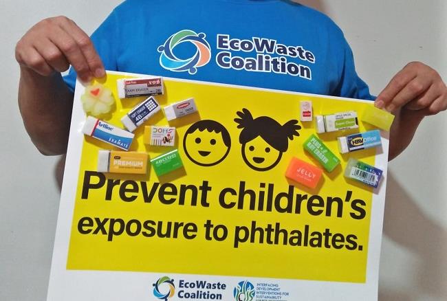 A person in an EcoWaste Coalition shirt holds a sign with toy and colored erasers attached. The sign reads, Prevent childrens exposure to phthalates. EcoWaste Coalition logo is at the bottom.