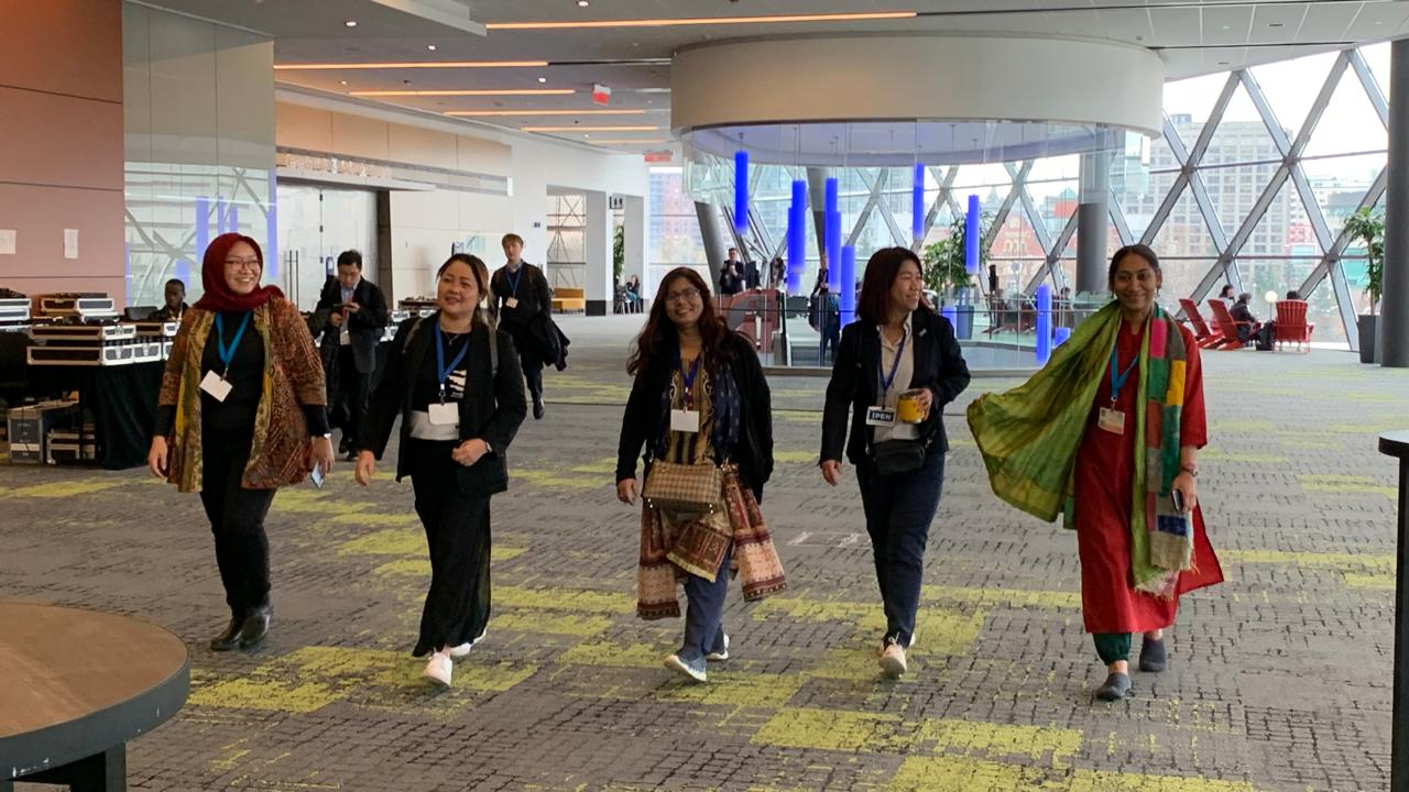 four women striding down a hall at a global policy meeting