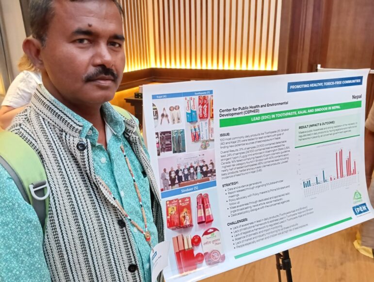 A man stands beside a poster presentation about tobacco and smoking in Nepal, featuring text, images of tobacco products, and charts. The background includes vertical wooden panels and lighting.